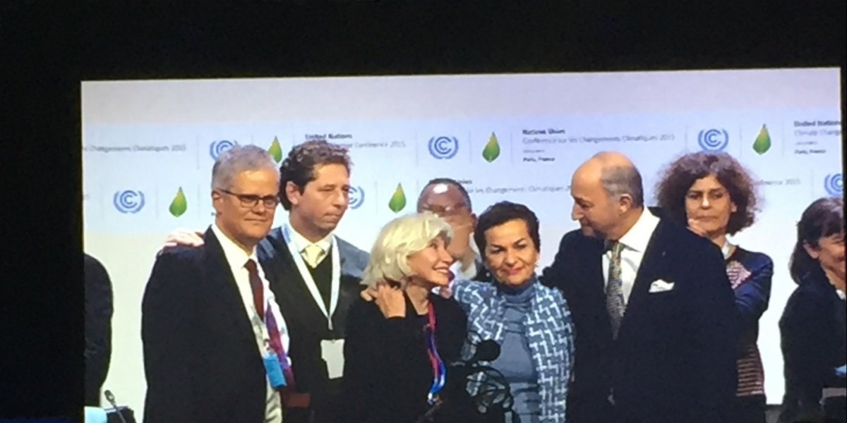 folk klemmer med Figueres i midten under signeringen av Parisavtalen