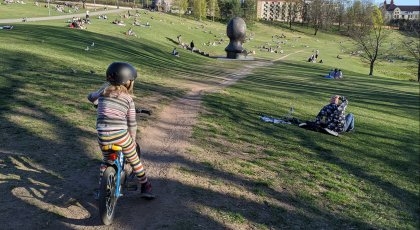Jente sykler i park i Oslo. 