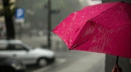 Regnvann drypper fra en rosa paraply