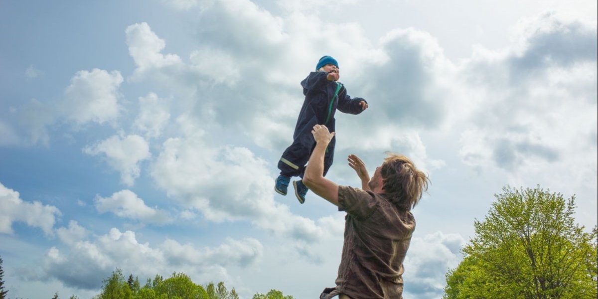 Bilde av mann som kaster sitt barn opp i luften