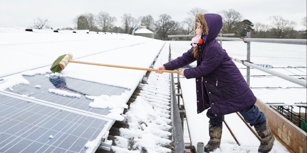 Barn måker snø på solcelle 